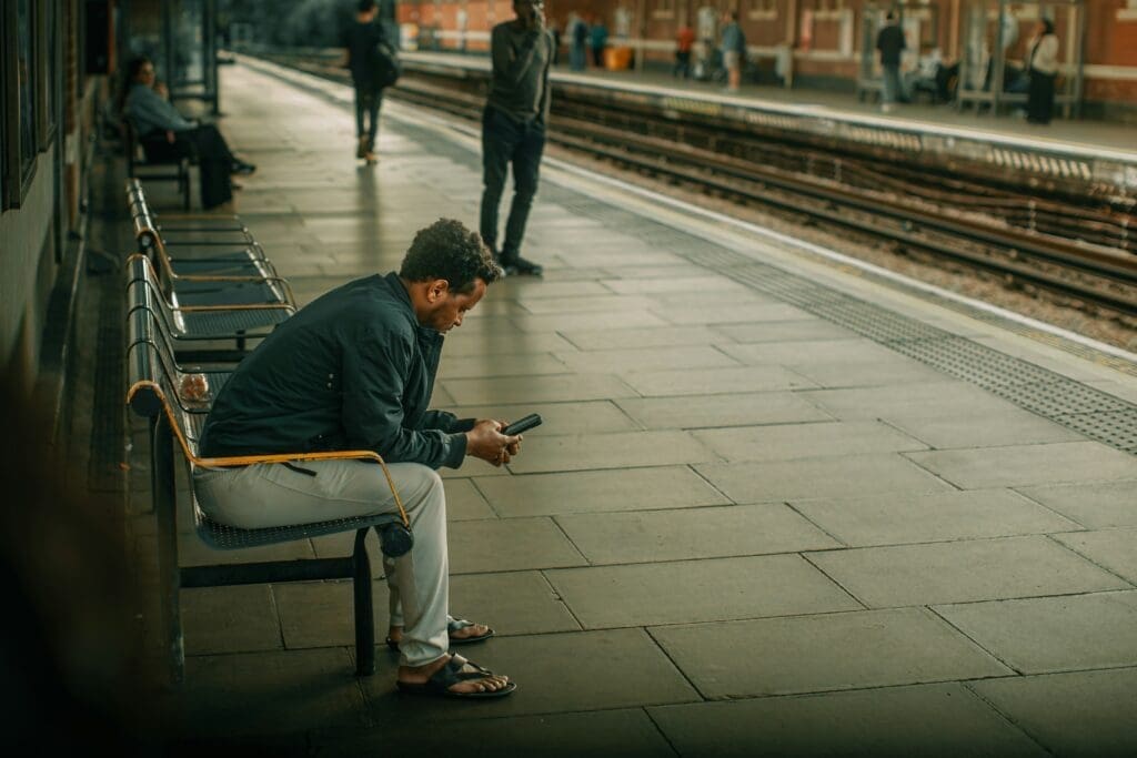 Man in tube looking at his phone
