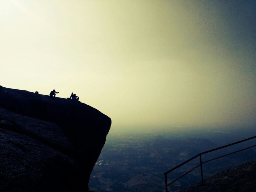 Men on the edge of a mountain showing risky behaviour